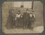 Carrie Eliza, Irma, Judith, Guilford Graham, and Cavour Hartley standing with Minae Ahrens against the Hartley house at 1305 East Superior Street