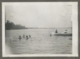 Members of the Hartley family swimming in Cass Lake near a canoe