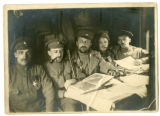 Group of soldiers at table with maps and papers