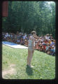 Girl stands in front of campers at Camp Butwin with a gymnastics mat, Eagan, Minnesota