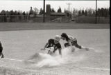 Action shot of UMD 1987 women's softball players sliding to base