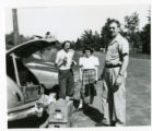 Suzon Karon, Janet Karon, and Robert J. Karon standing by the open trunk of a car