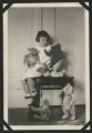 Child sitting on a small table surrounded by teddy bears