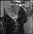 Student choosing song from jukebox in Ven Den lounge AT umd