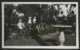 Five unidentified people in a garden at a house