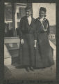O. Lingard and M. Sharpe standing in front of the front steps of a house