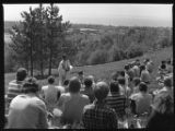 A priest giving a sermon to a crowd at a mass on Rock Hill