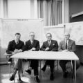 Faculty members at desk with maps