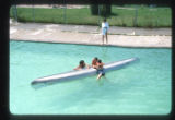 Campers and a staff member with a canoe in the pool at Camp Butwin, Eagan, Minnesota