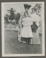 Judith and Jessie Hartley standing with another person in the front yard of a house