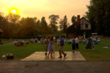Couples dancing on Glensheen's Carriage House lawn with Gardener's Cottage in the background